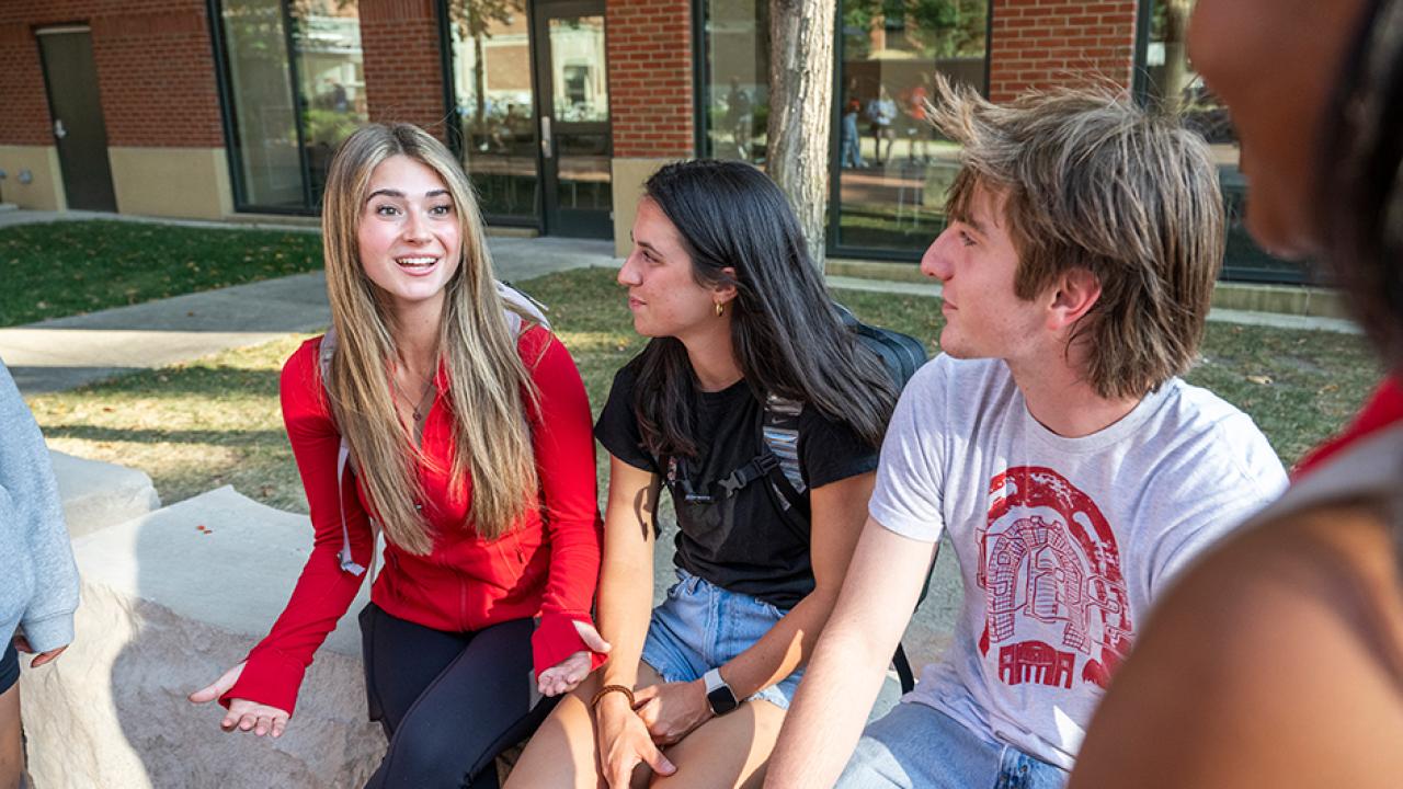 Three students having a discussion on campus